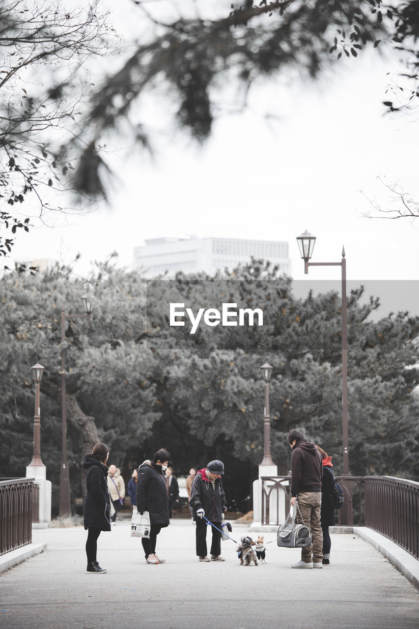 GROUP OF PEOPLE WALKING ON STREET IN CITY