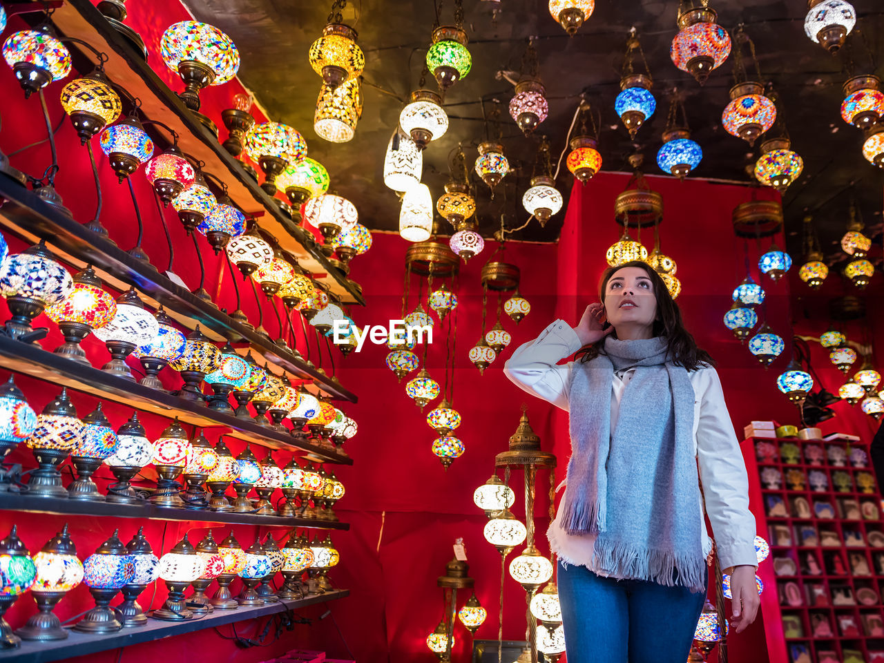 Low angle view of woman standing by illuminated lanterns