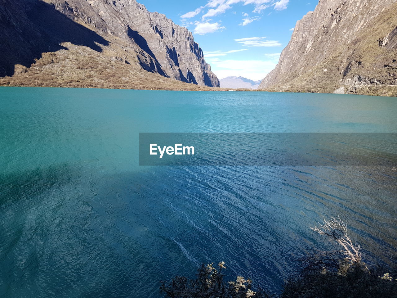 Scenic view of sea by mountains against sky