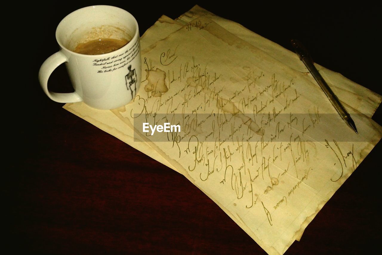 Close-up of coffee cup and letter