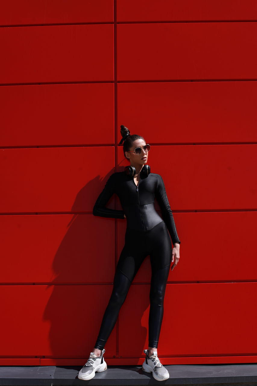 low angle view of silhouette person standing on yellow wall