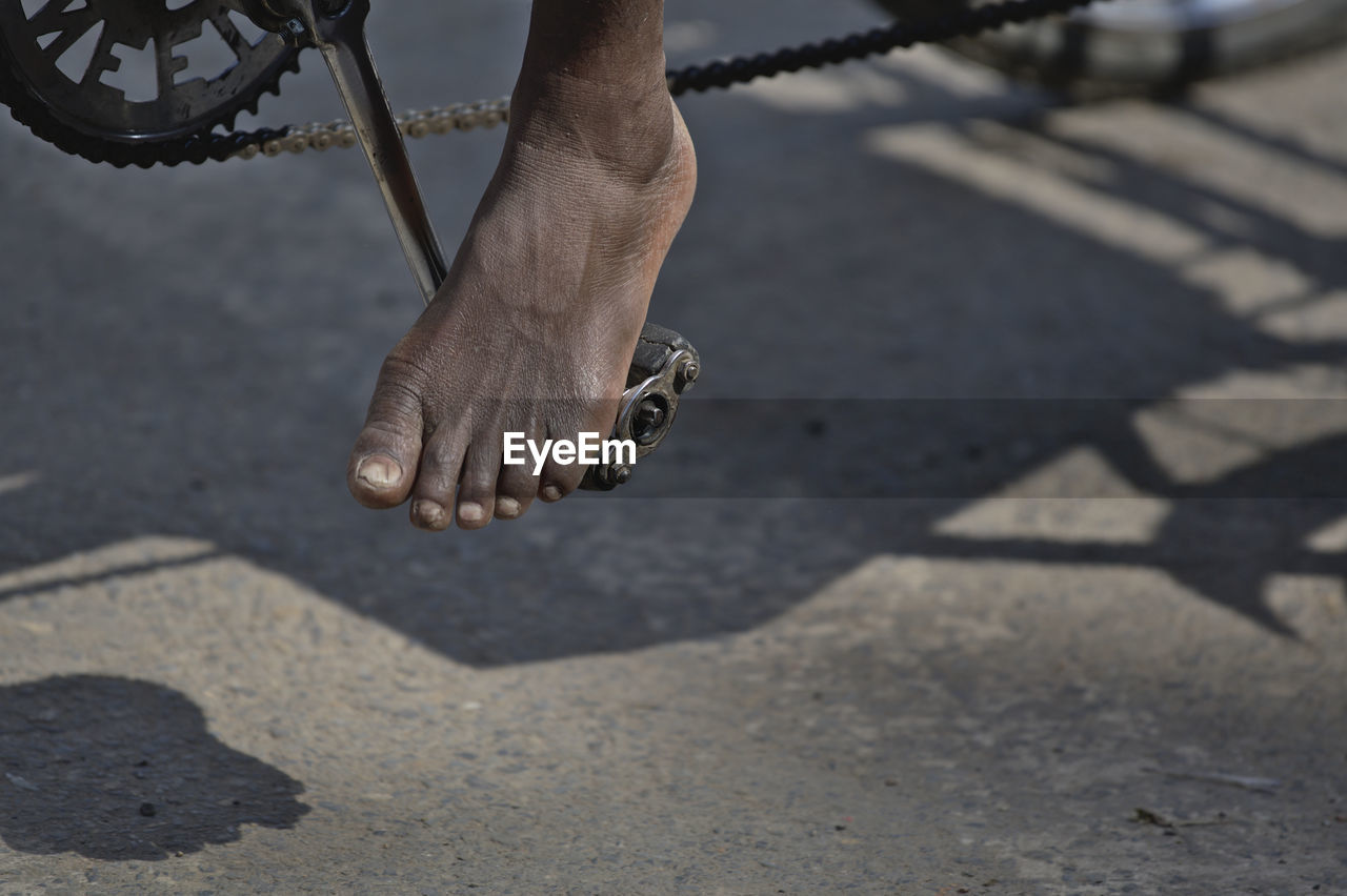 Low section of man riding bicycle on street