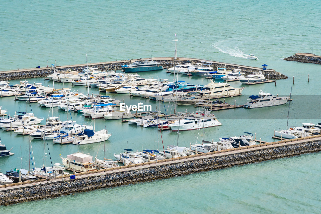 HIGH ANGLE VIEW OF SAILBOATS MOORED ON SEA