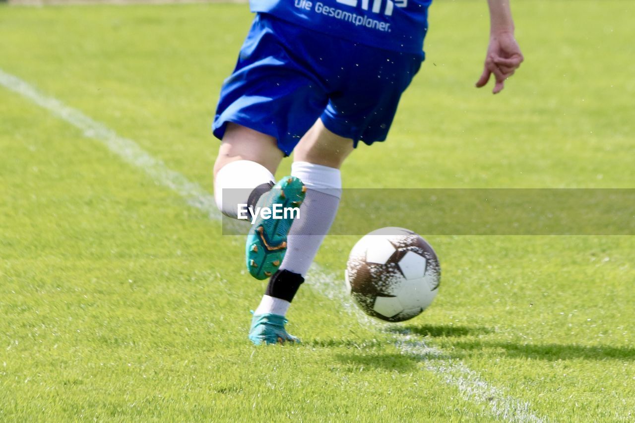 low section of man playing soccer at baseball