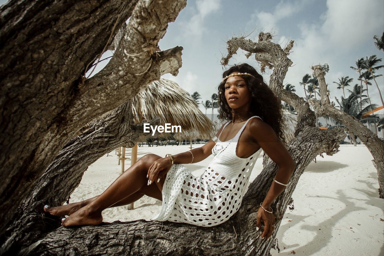 Portrait of woman against tree trunk