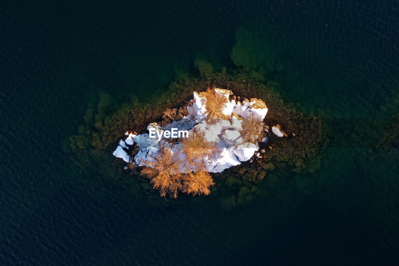 Aerial view of snowcapped mountains amidst water