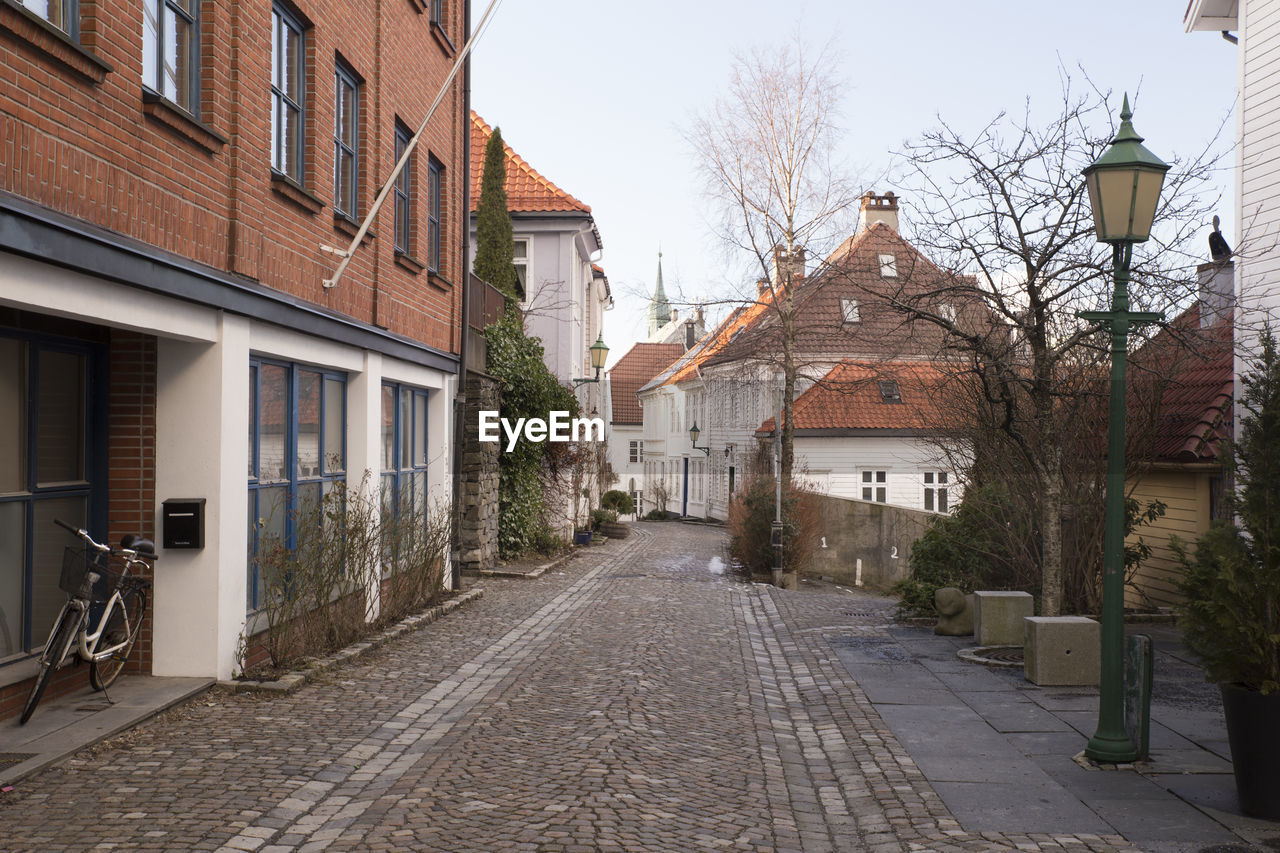 Street amidst houses against sky