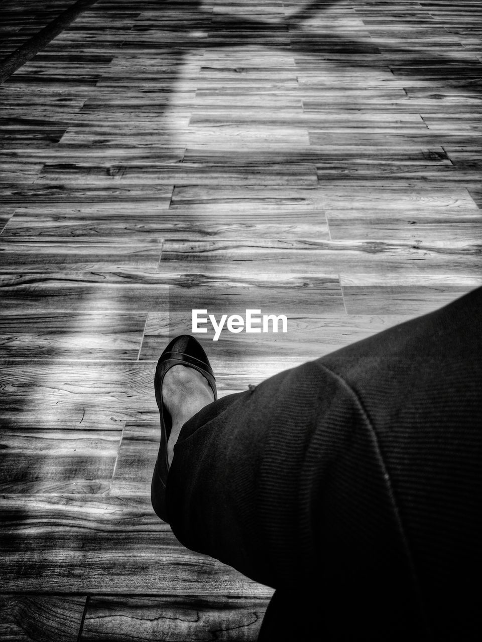 LOW SECTION OF MAN STANDING ON WOOD FLOOR