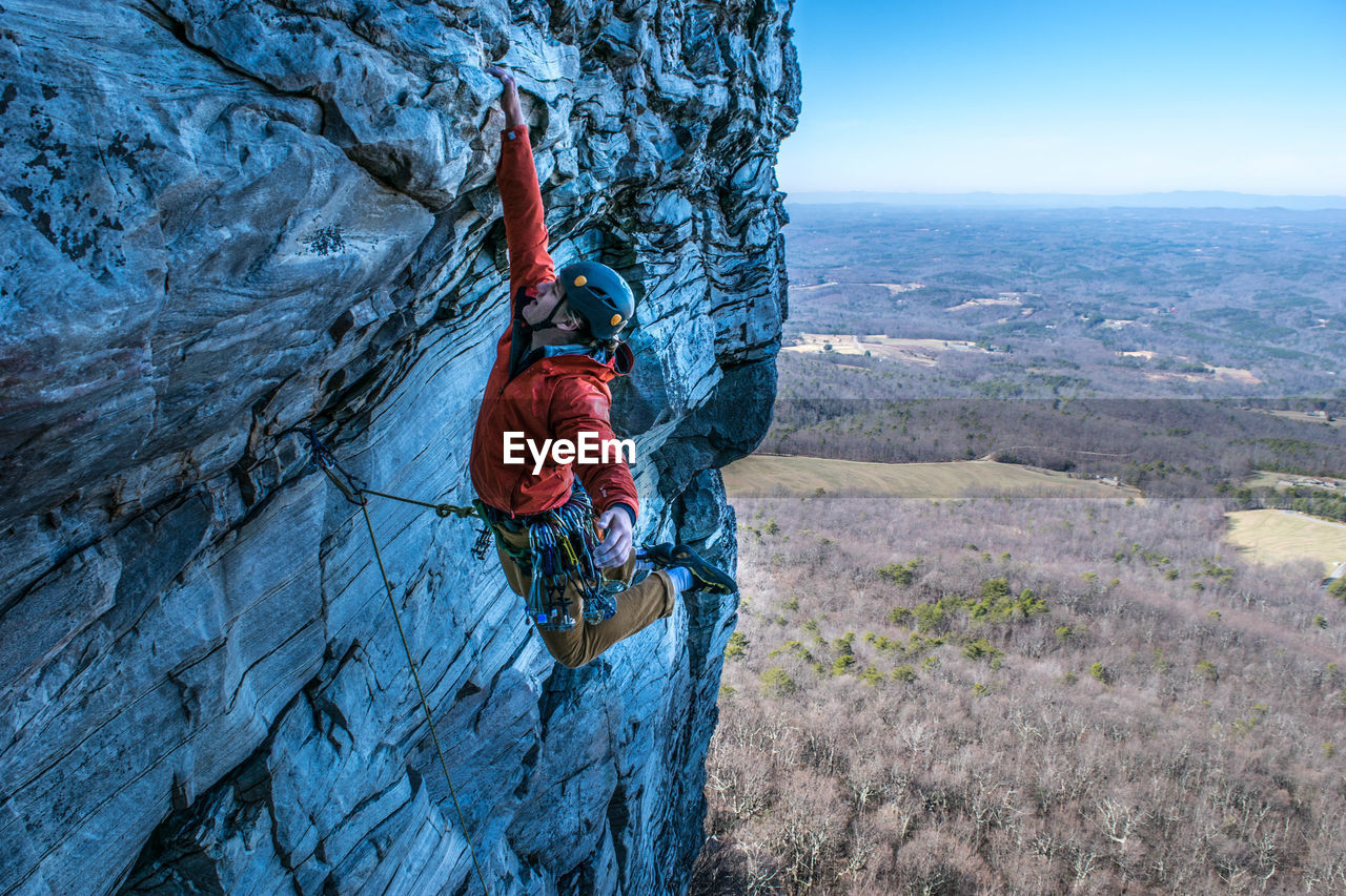 Man rock climbing against landscape