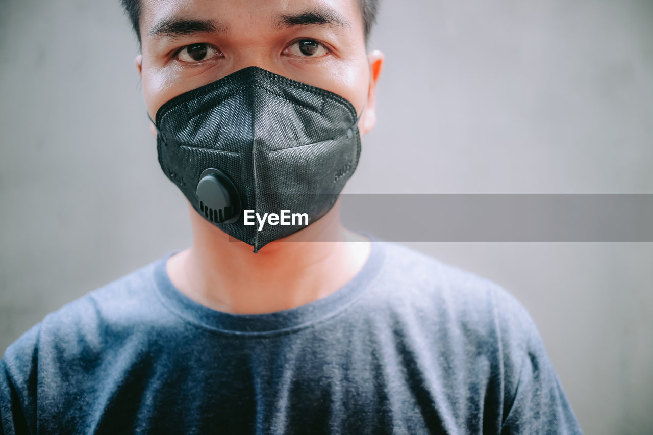 CLOSE-UP PORTRAIT OF A YOUNG MAN WEARING MASK