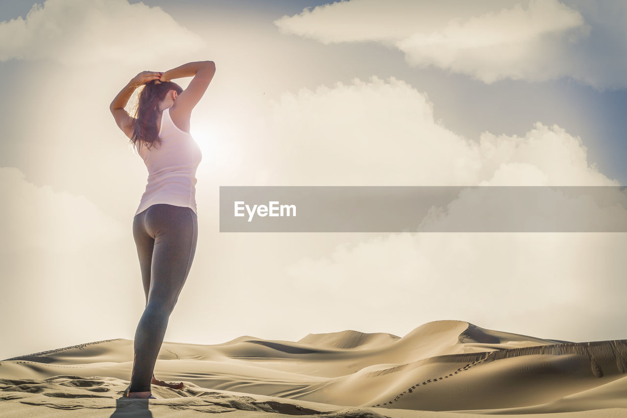 Woman standing on beach against sky