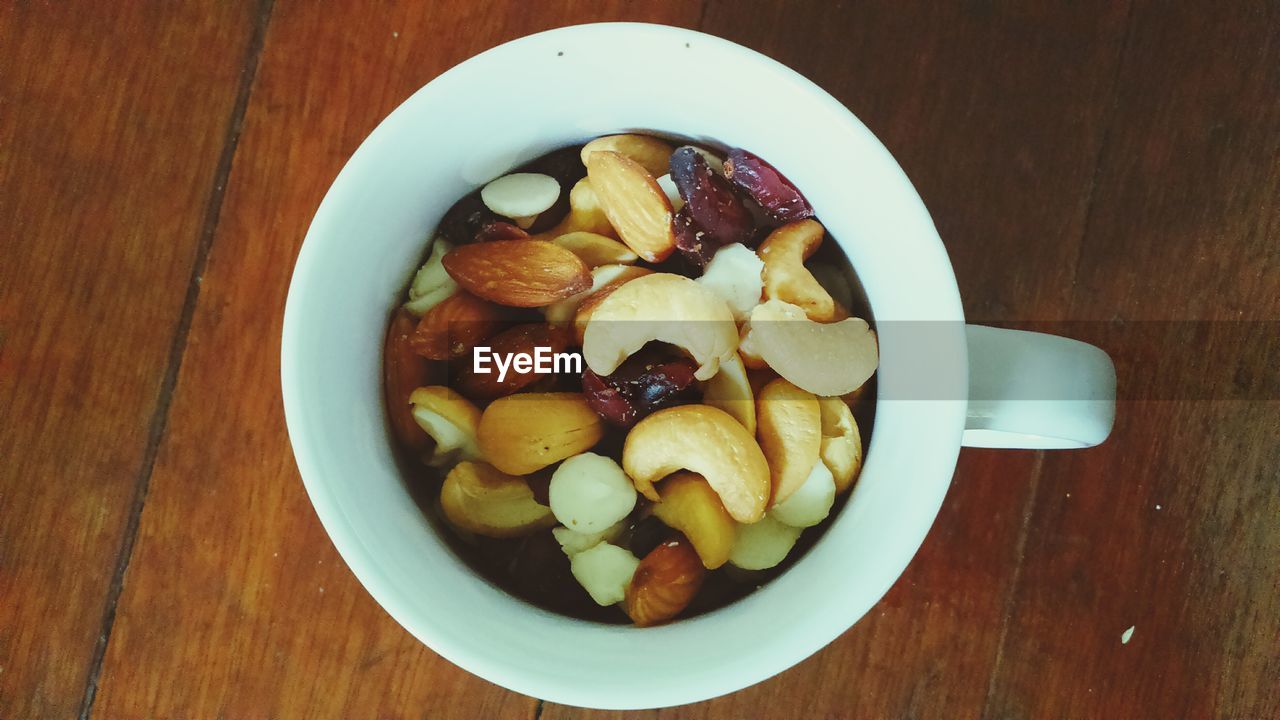 Close-up of dry fruits in coffee cup on table