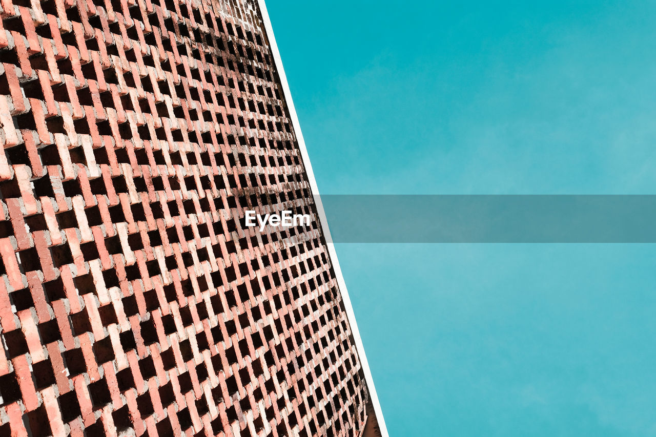 Perforated brick wall against  blue sky