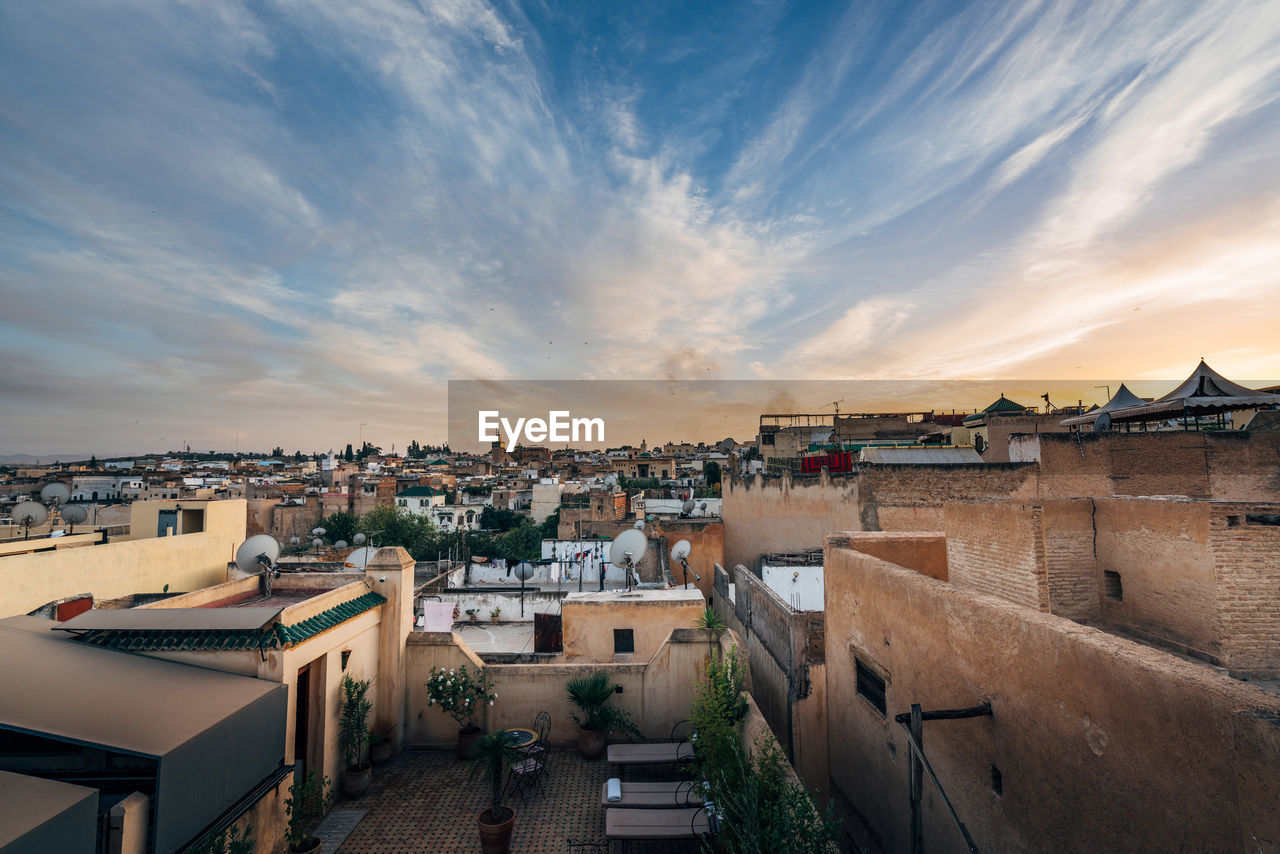 View of cityscape against cloudy sky