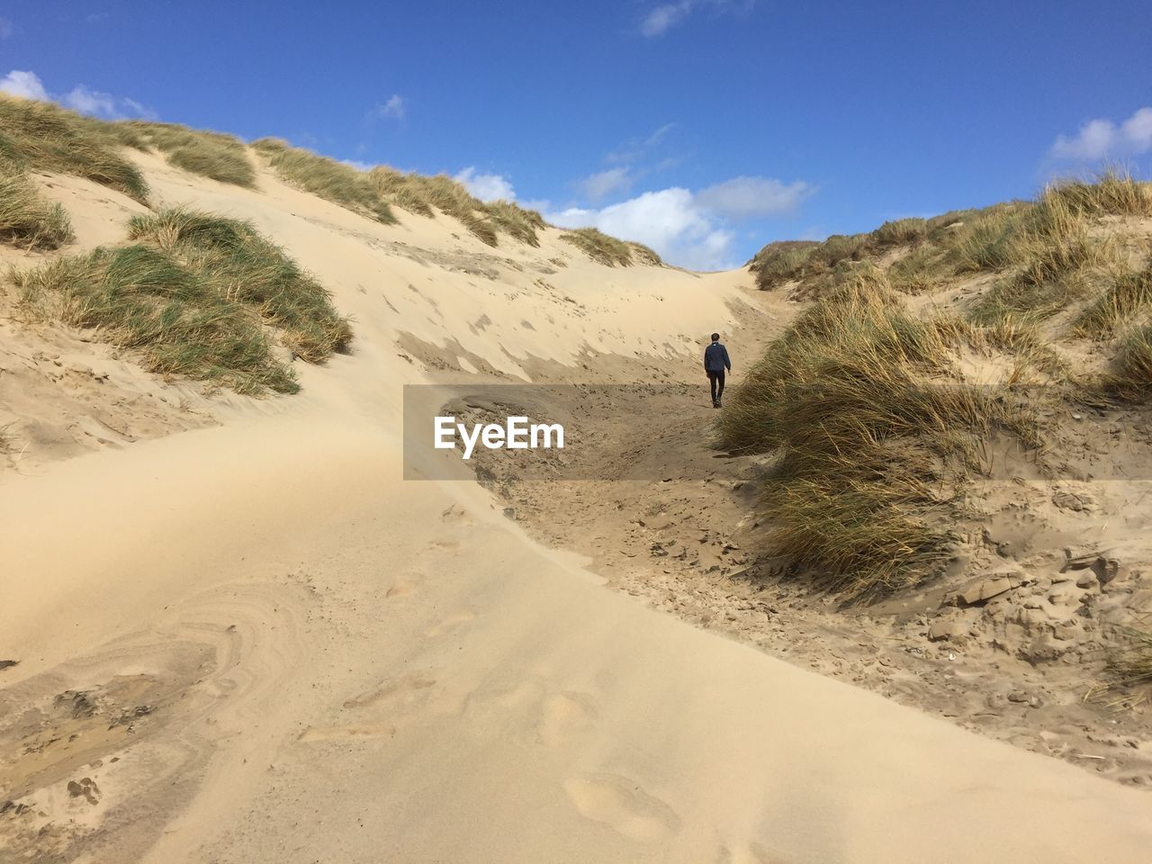 Rear view of person walking at camber sands beach