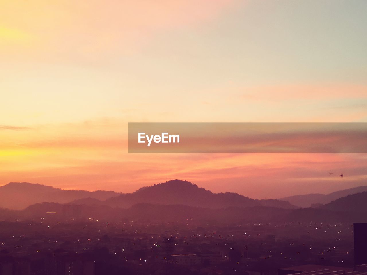 Scenic view of silhouette mountains against romantic sky at sunset