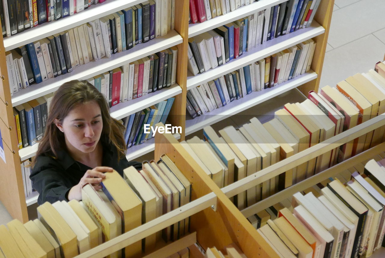 Close-up of young woman reading book in library