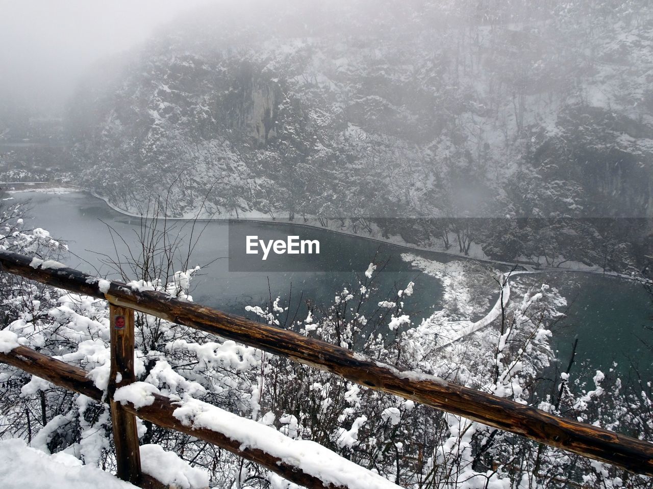 CLOSE-UP OF FROZEN LAKE AGAINST SNOW