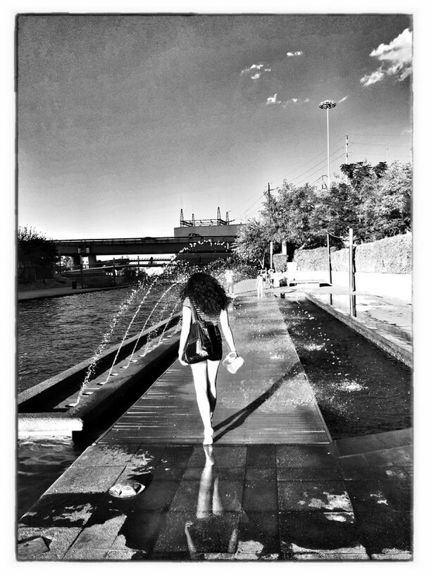 FULL LENGTH OF YOUNG WOMAN STANDING ON RAILING