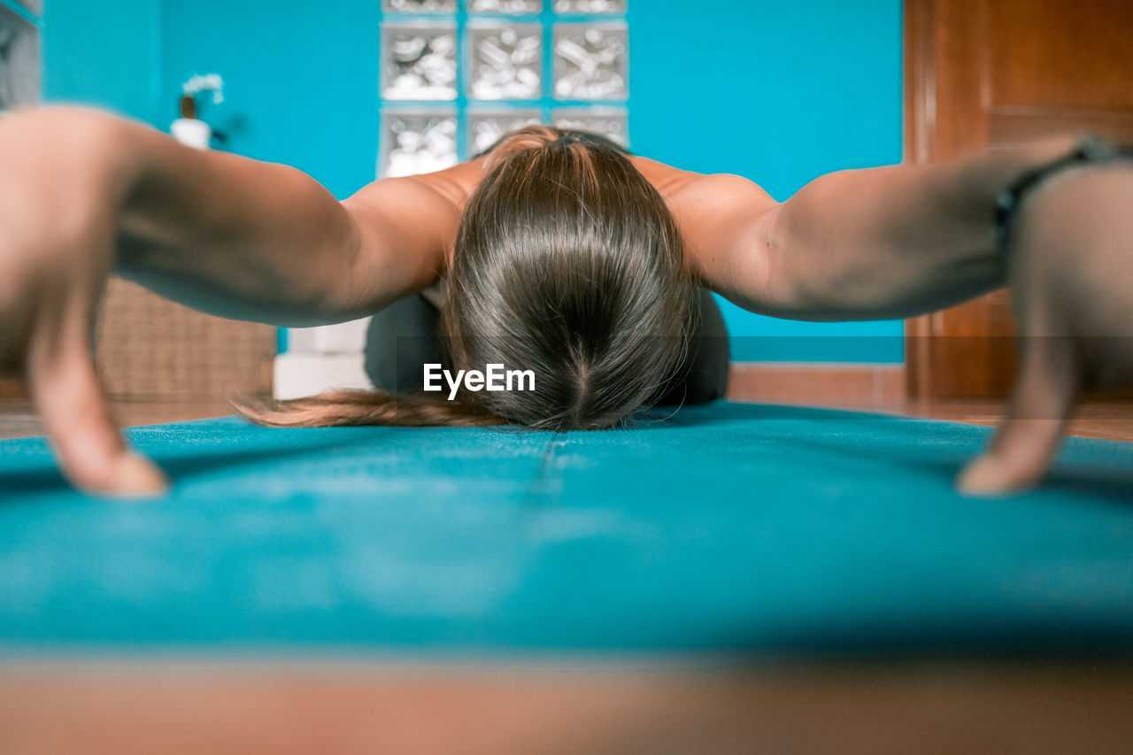 Woman exercising while sitting on mat at home