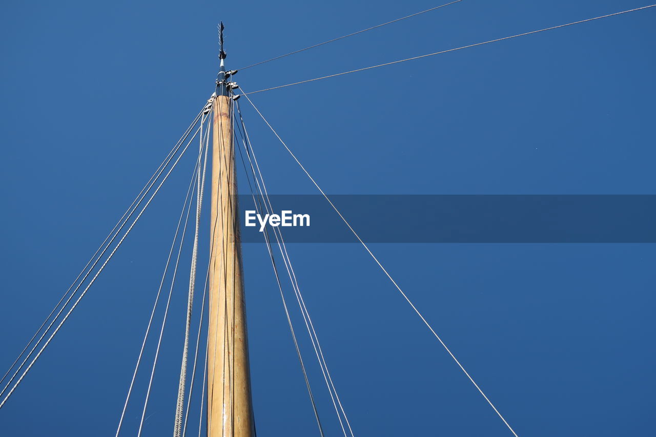 Low angle view of mast against clear blue sky