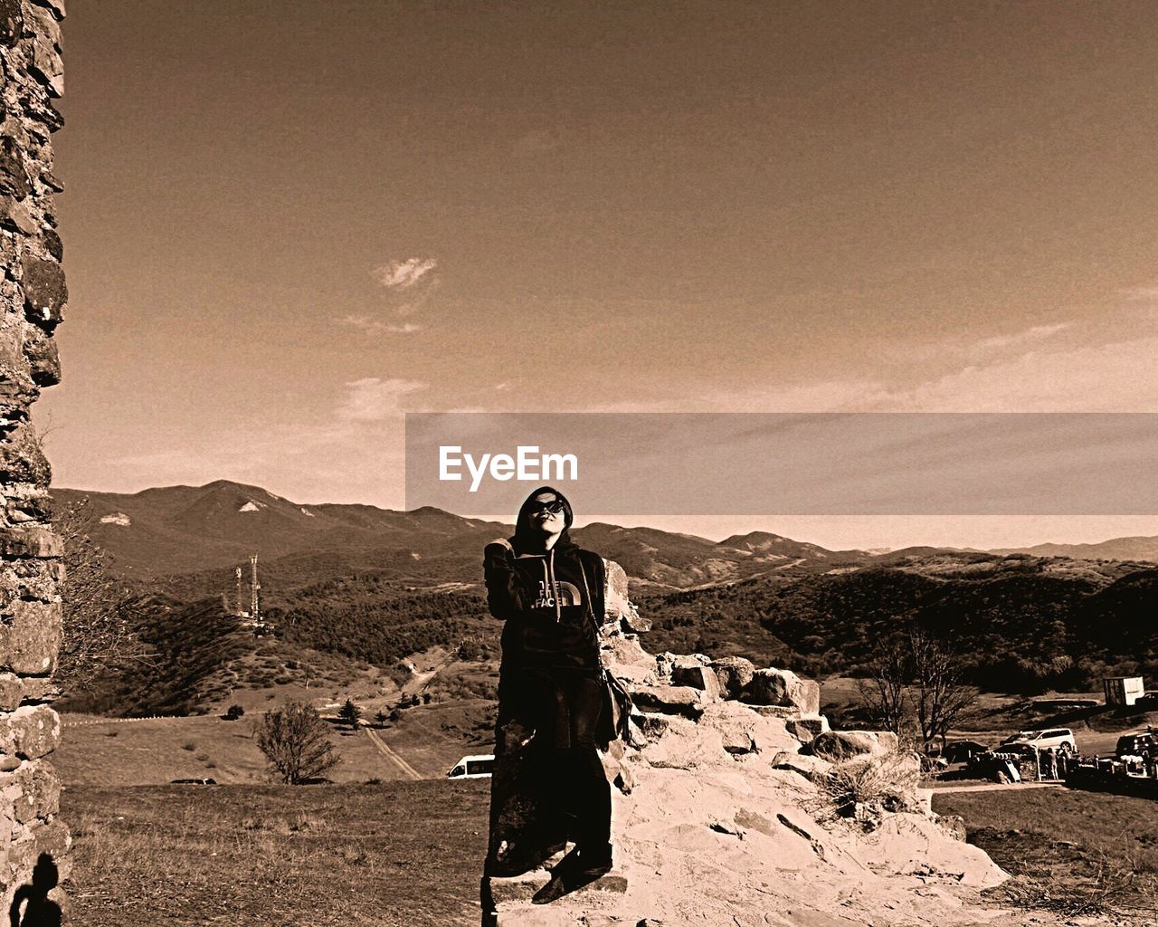 WOMAN STANDING ON MOUNTAIN LANDSCAPE