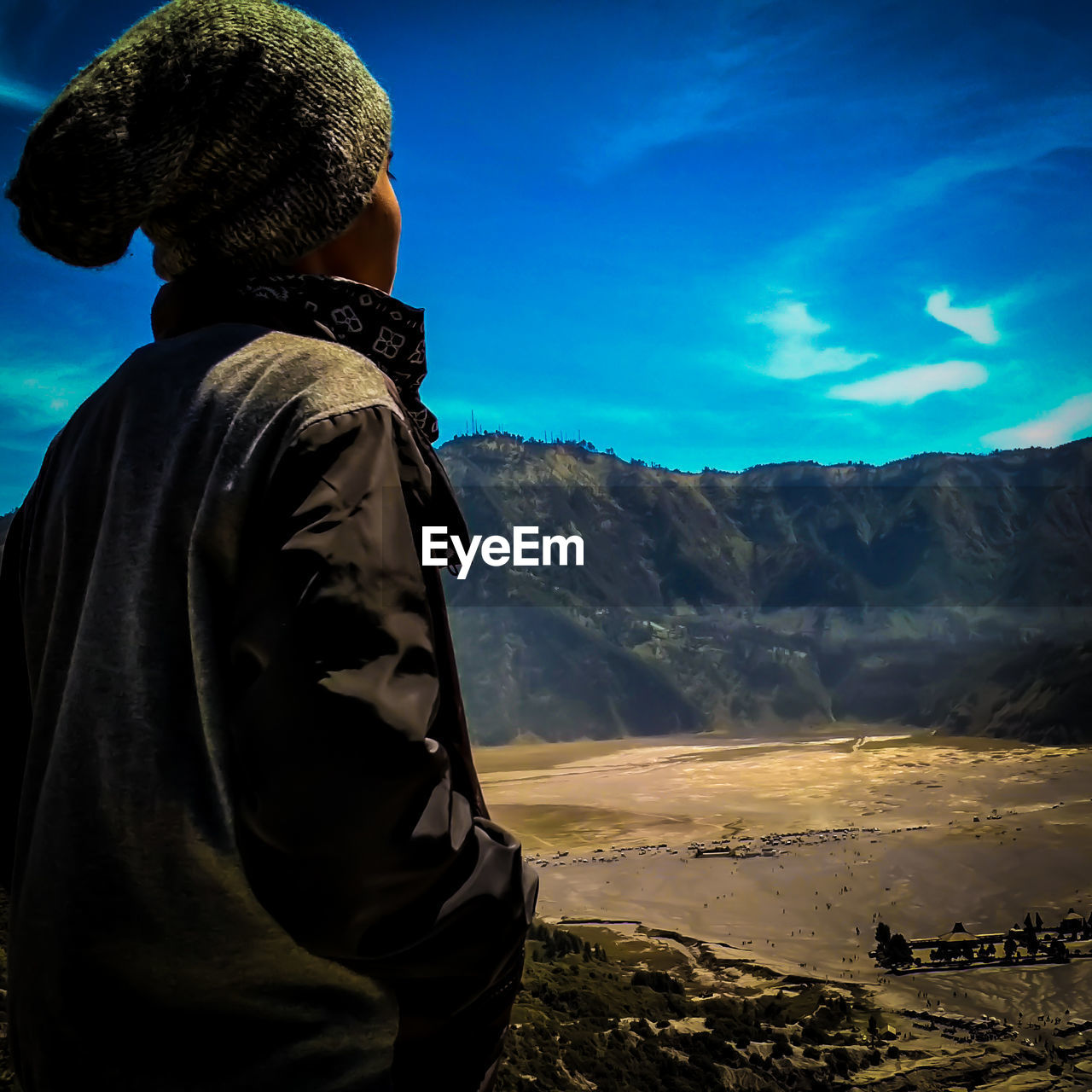 Side view of man standing on mountain against sky