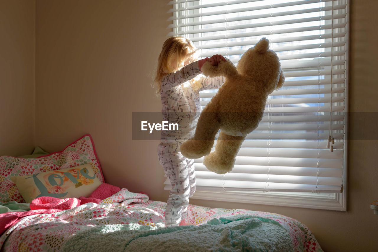 FULL LENGTH OF BABY GIRL WITH CAT ON BED