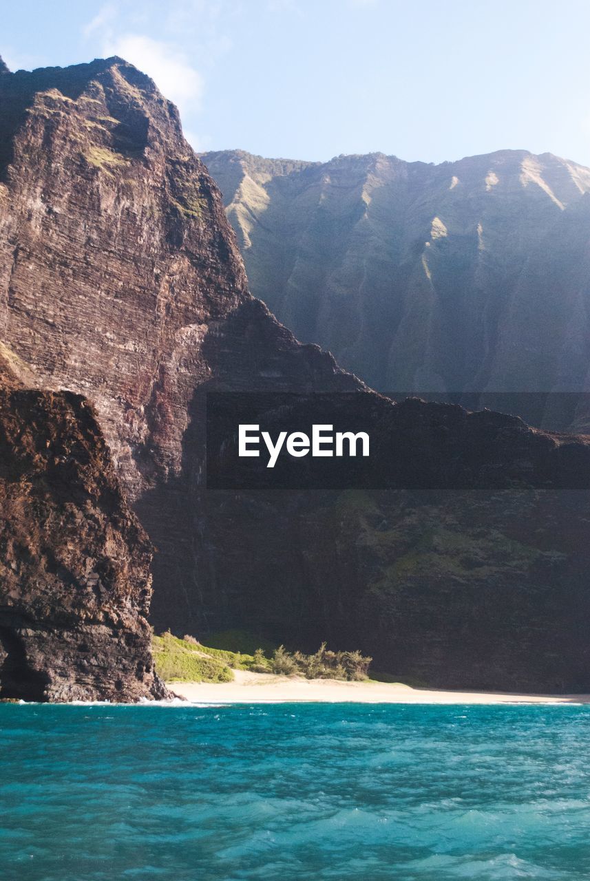 Scenic view of sea and mountains against sky