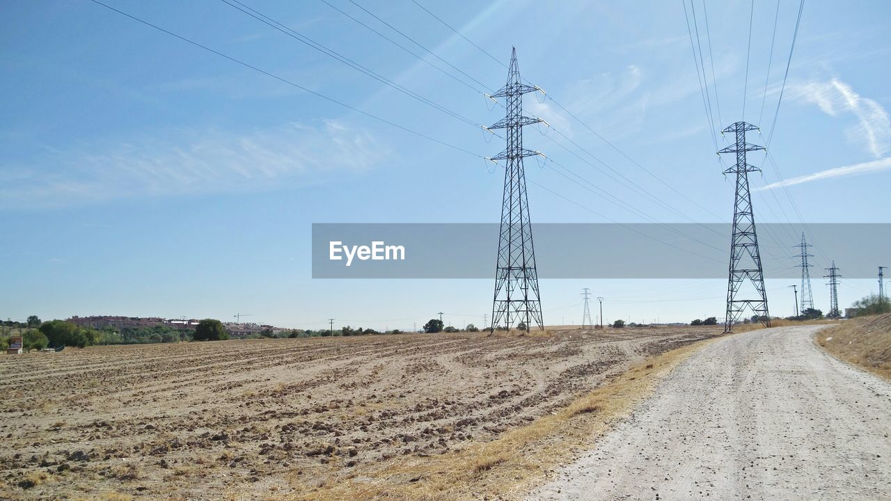 Electricity pylon on field against sky