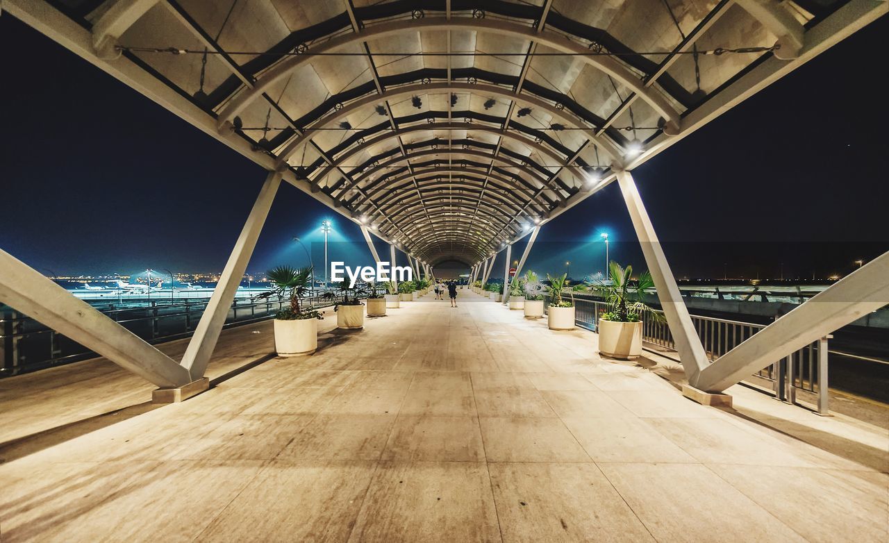 Covered footbridge at airport during night