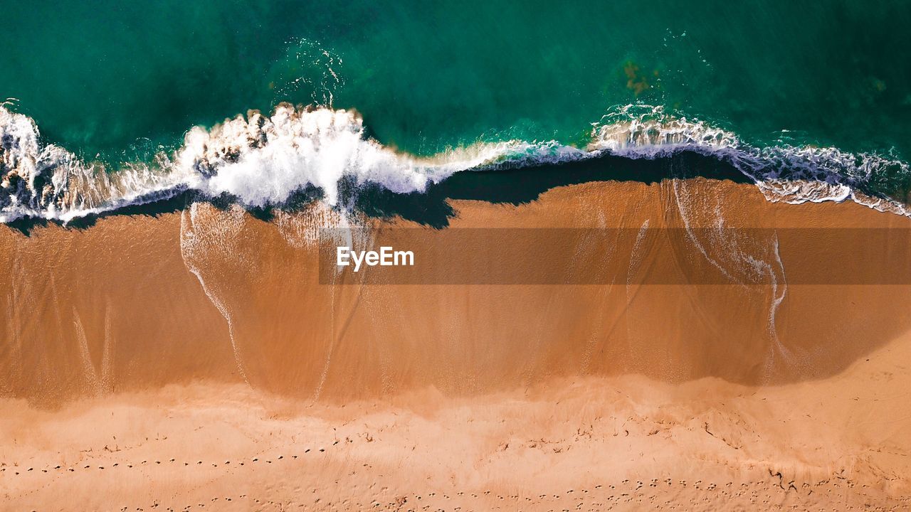 High angle view of surf on sea shore