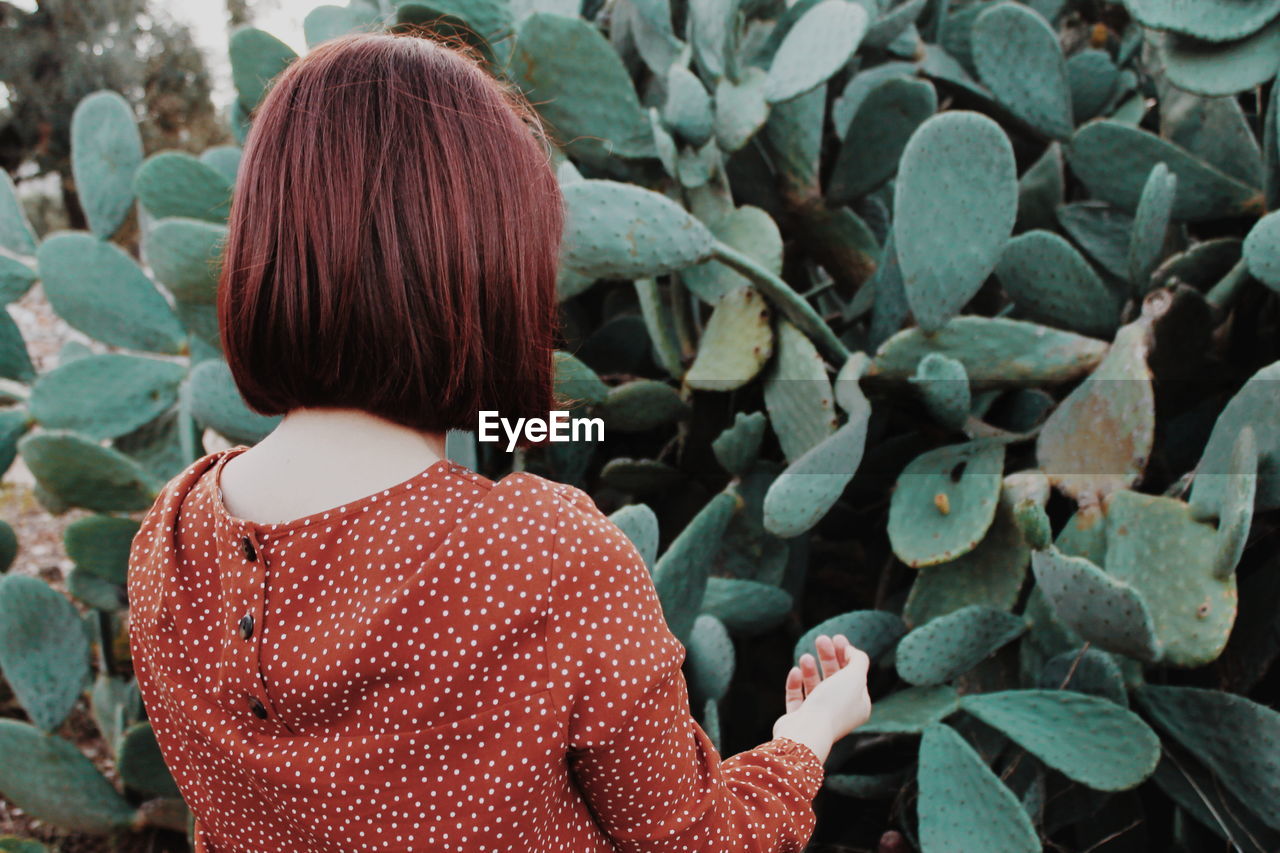 Rear view of woman standing against plants