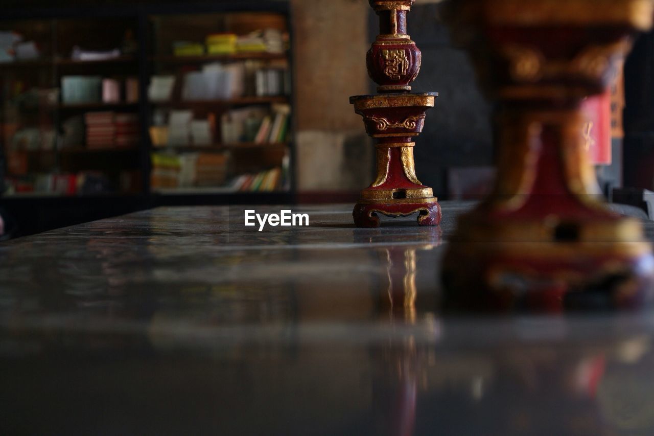 Close-up of centerpieces on table against bookshelf