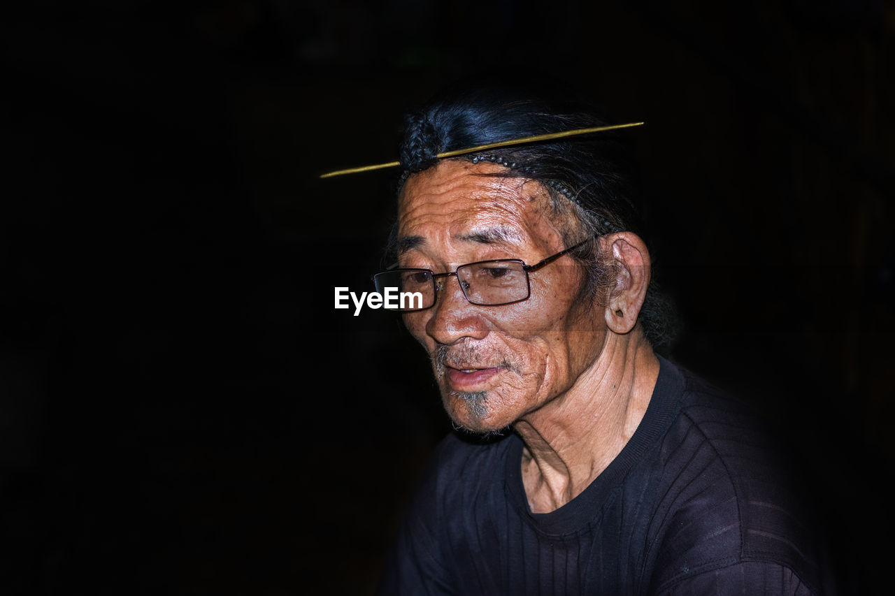 Portrait of man wearing mask against black background