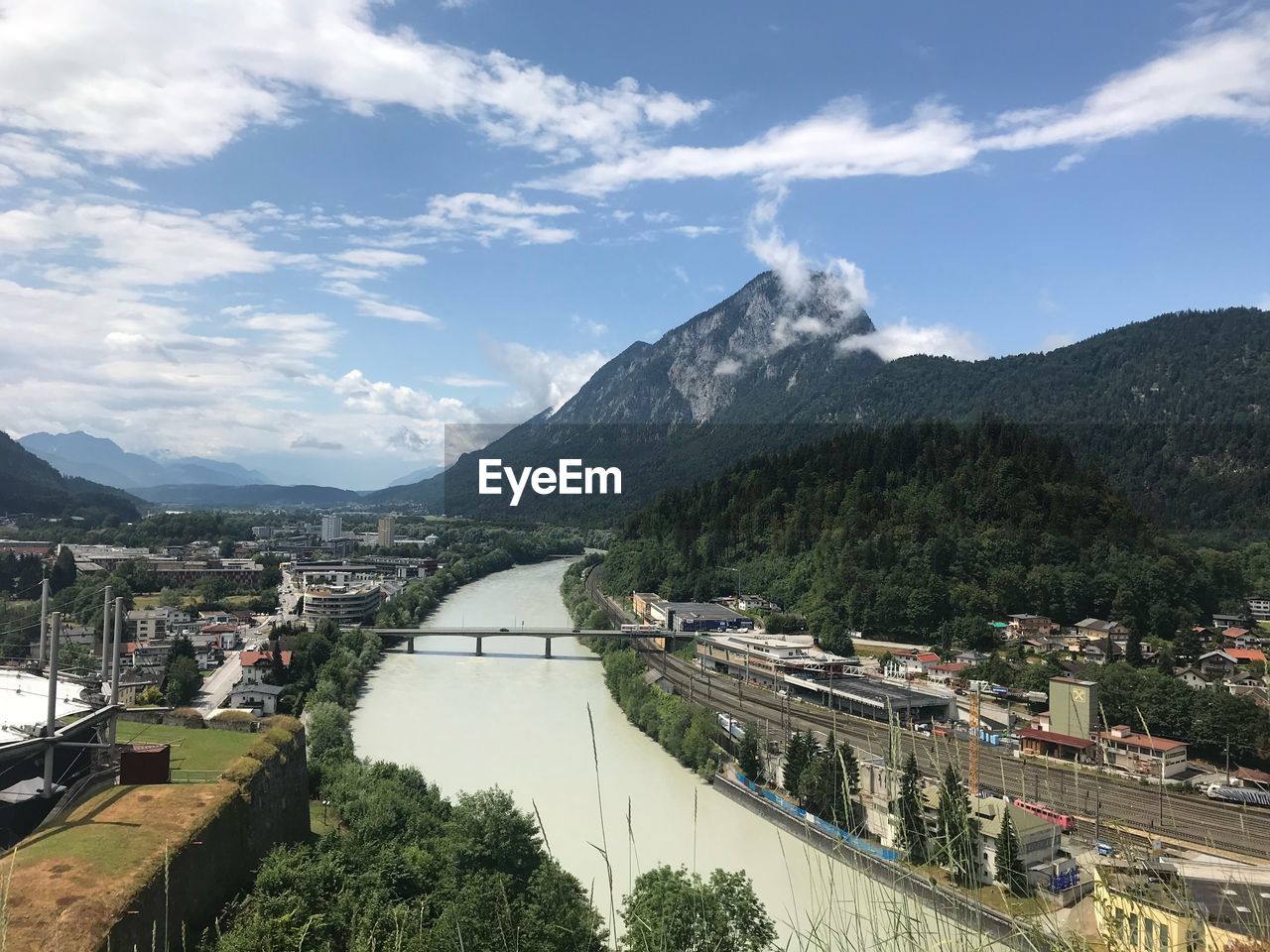 PANORAMIC VIEW OF BUILDINGS BY MOUNTAINS AGAINST SKY