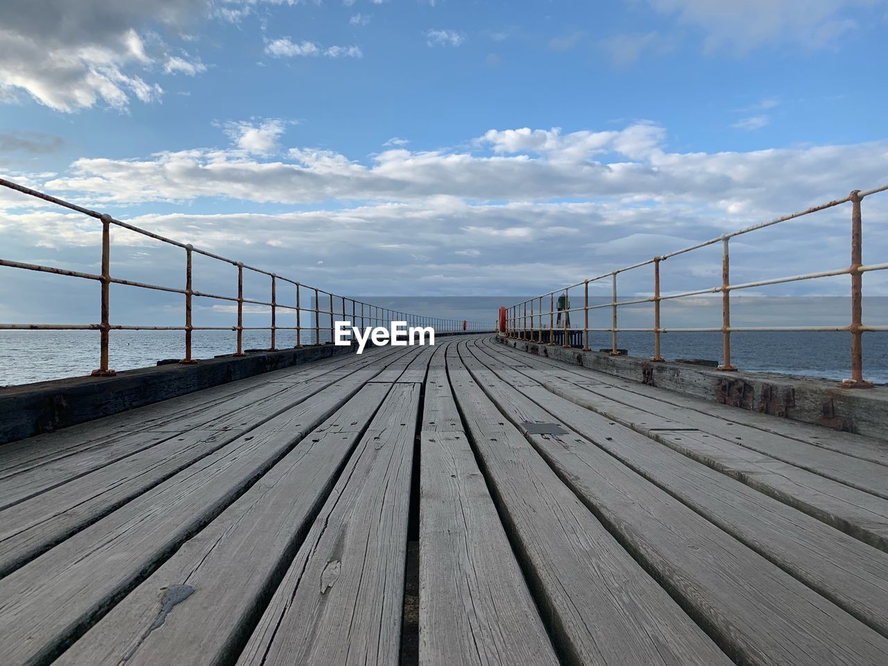 Surface level of pier over sea against sky