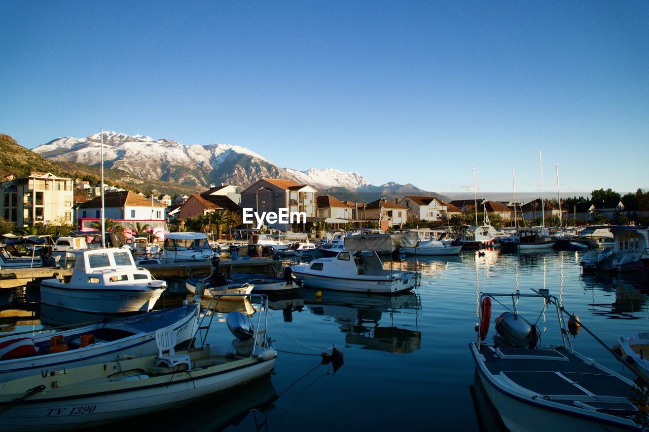 BOATS MOORED ON SEA AGAINST CLEAR BLUE SKY