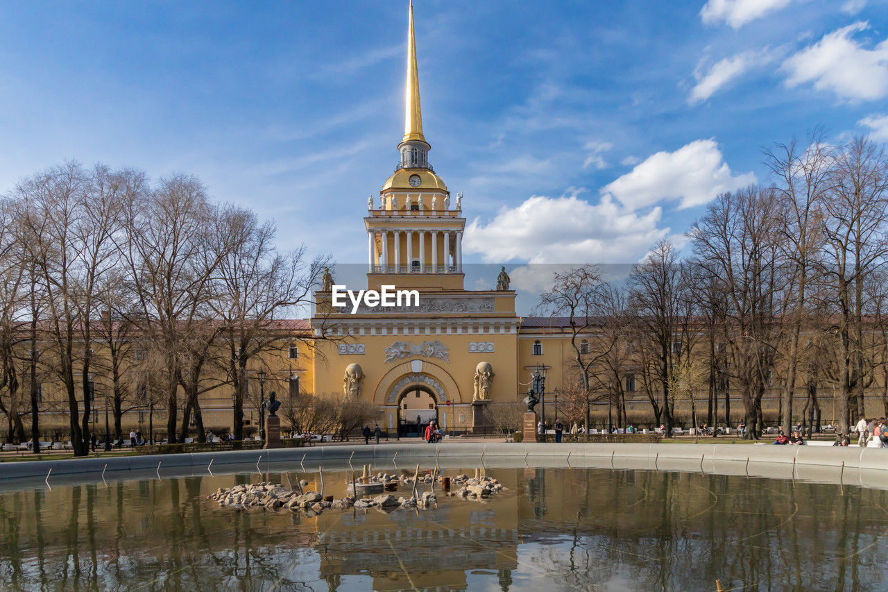 architecture, built structure, travel destinations, sky, building exterior, reflection, tree, water, nature, landmark, travel, bare tree, cloud, plant, history, tourism, the past, city, building, place of worship, lake, outdoors, religion, château, blue, politics and government, day, government, plaza, no people