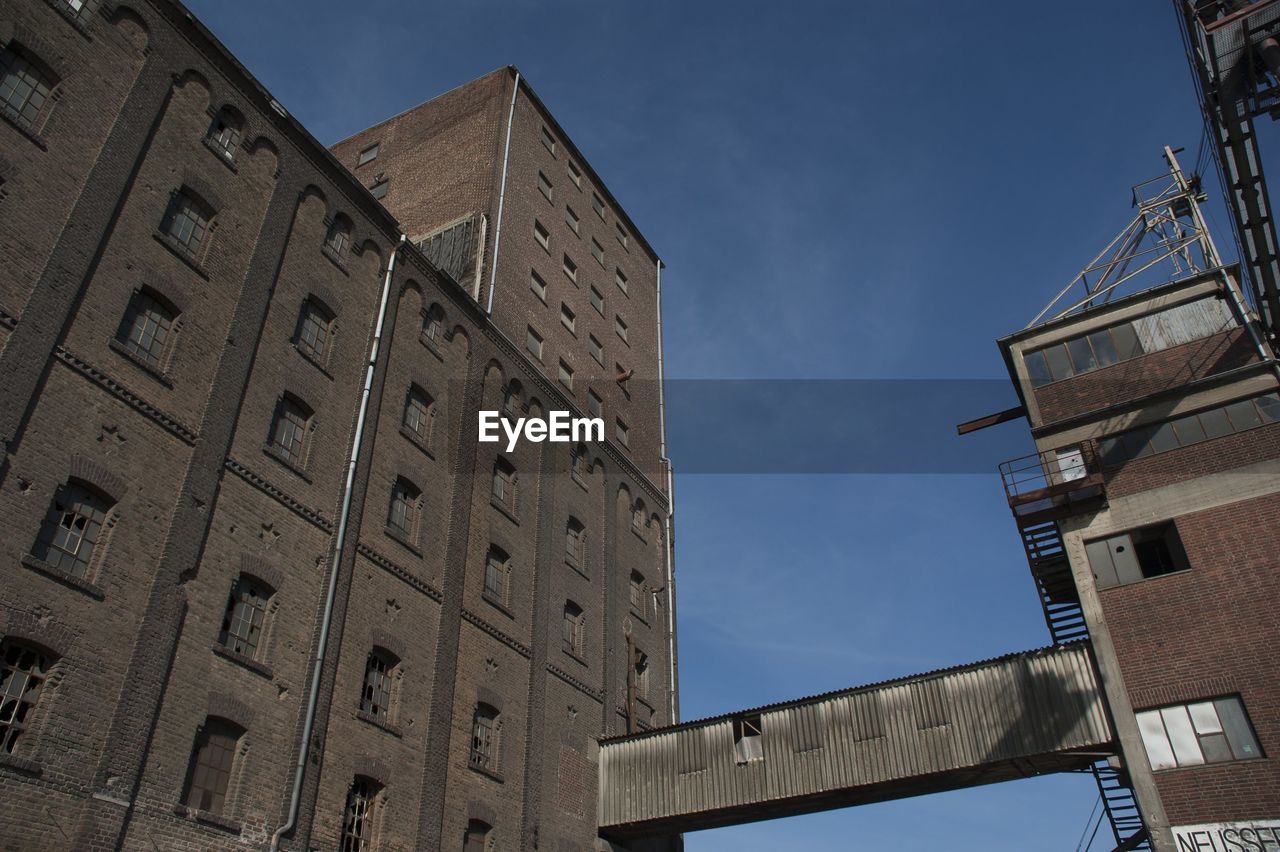 Low angle view of built structures against clear blue sky