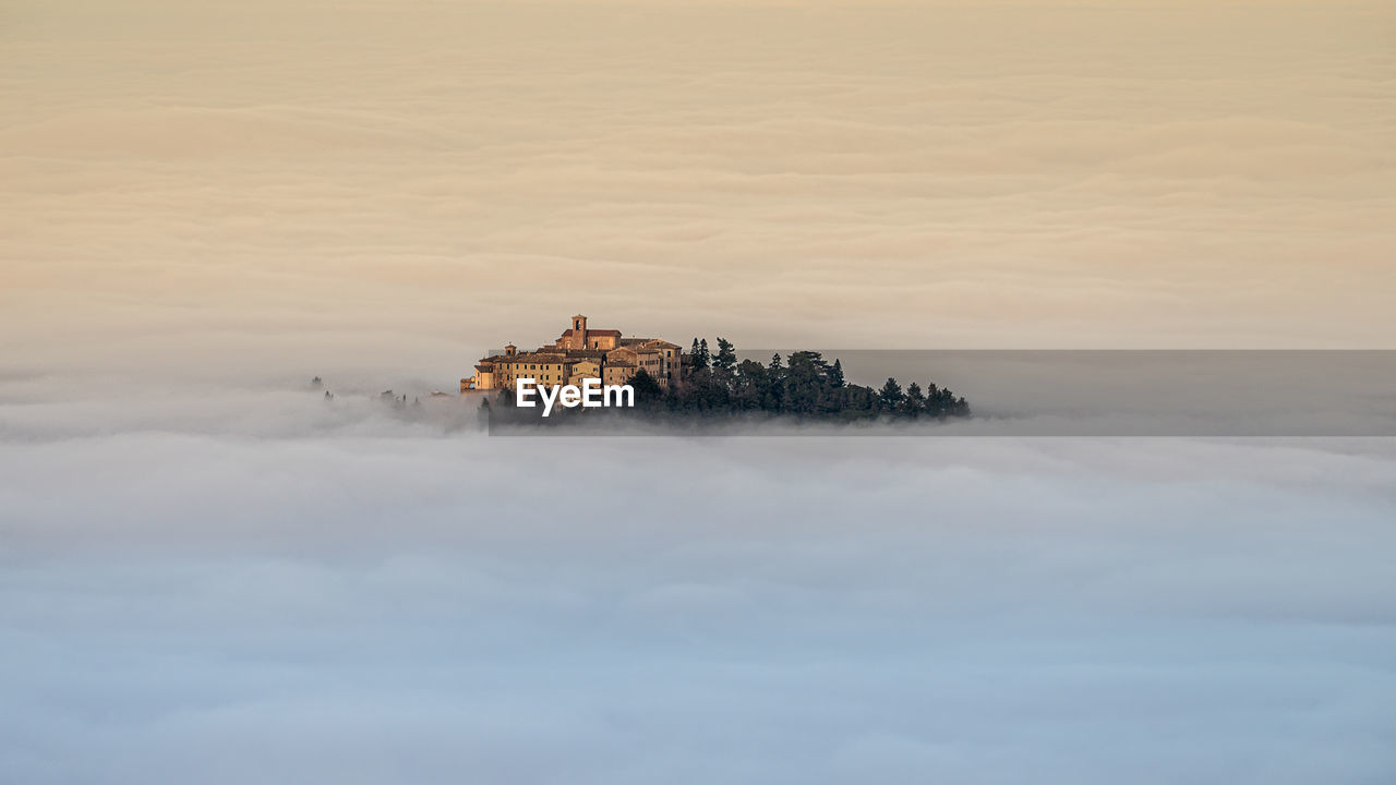 Italy january 2022, view of the village of piticchio di arcevia immersed in the fog, 