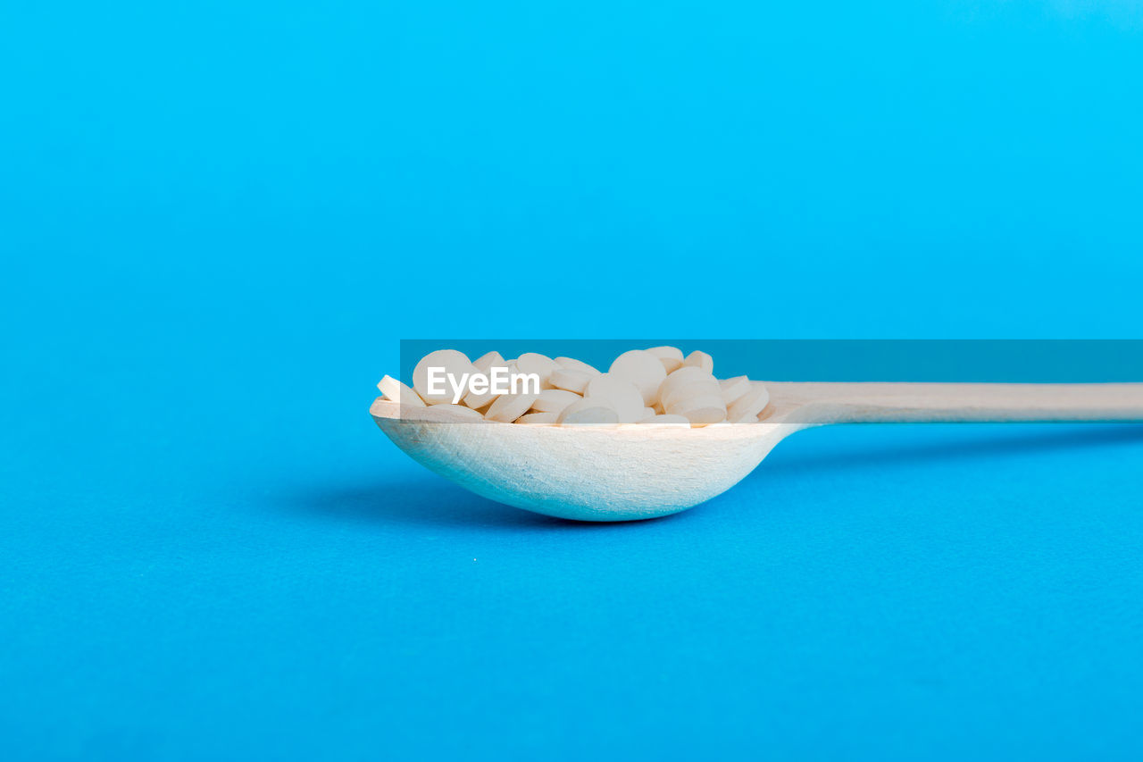 blue, colored background, food, studio shot, blue background, food and drink, wellbeing, indoors, copy space, no people, freshness, kitchen utensil, healthy eating, spoon, healthcare and medicine, cut out, still life, eating utensil, close-up