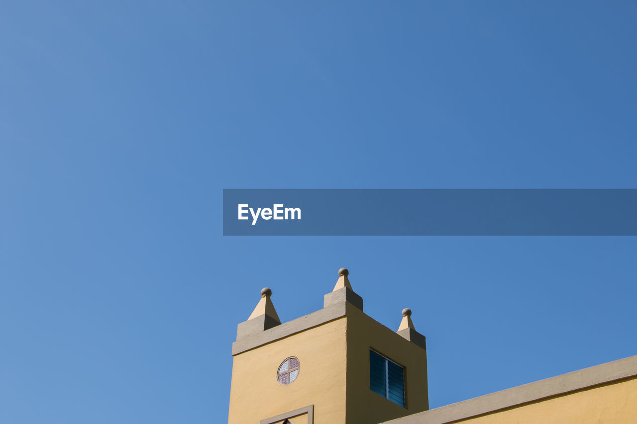 High section of building against clear blue sky