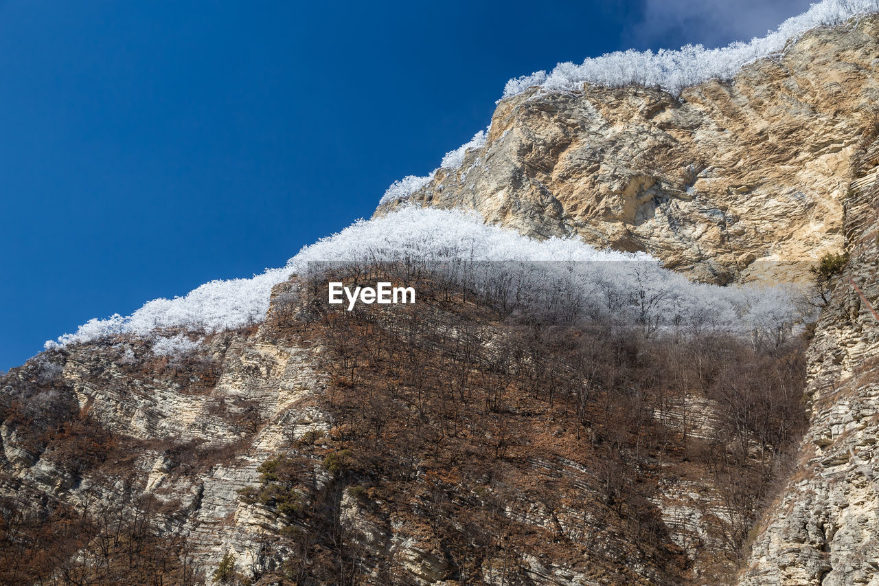 Winter in the mountains of chechnya. low angle view of rock formation against sky