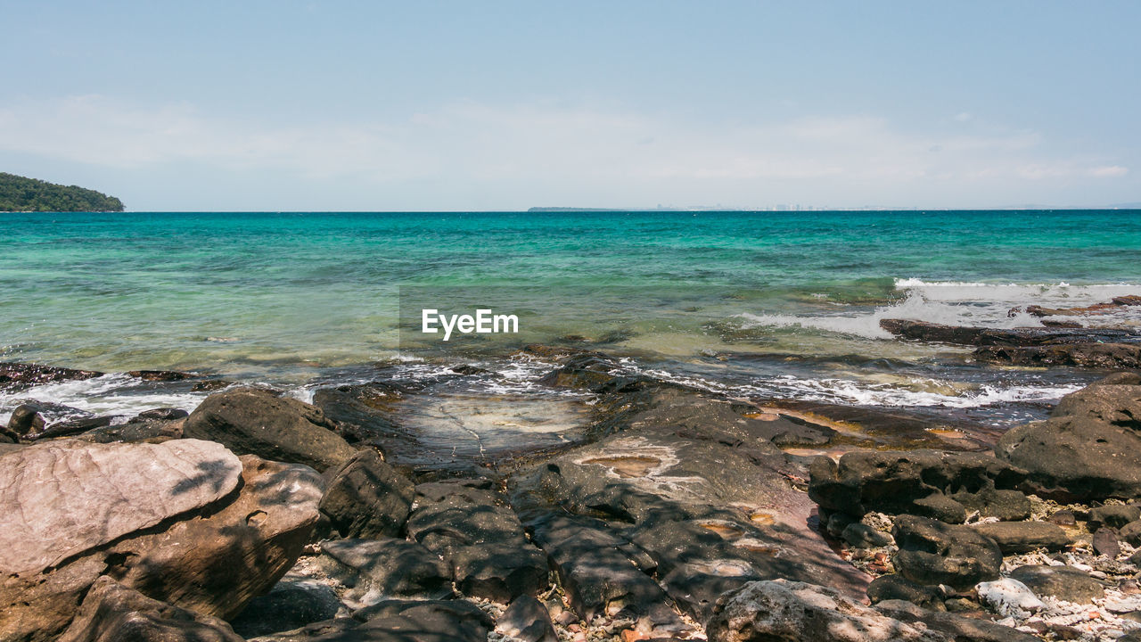 SCENIC VIEW OF ROCKS ON SHORE AGAINST SKY