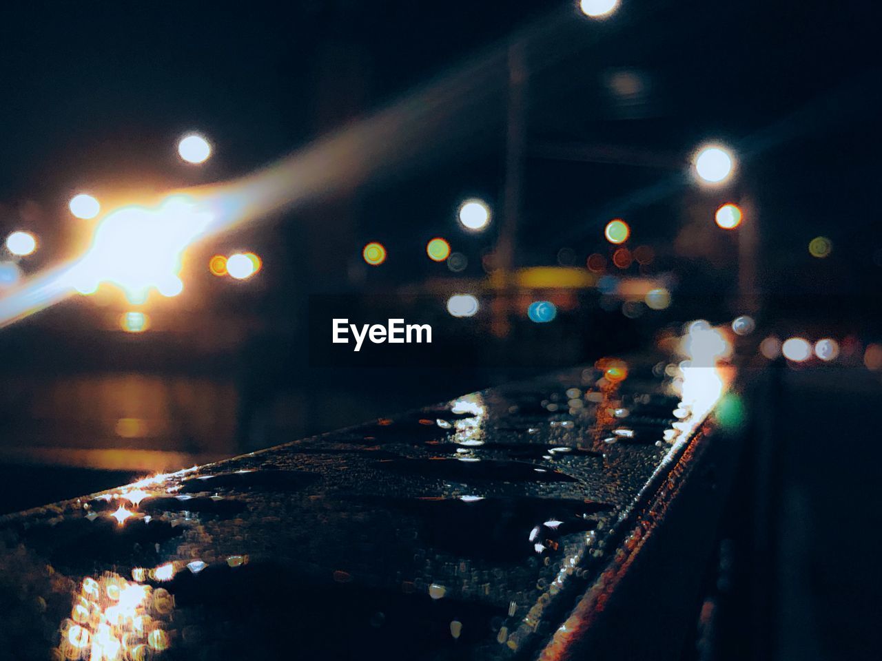 Illuminated city street during rainy season at night