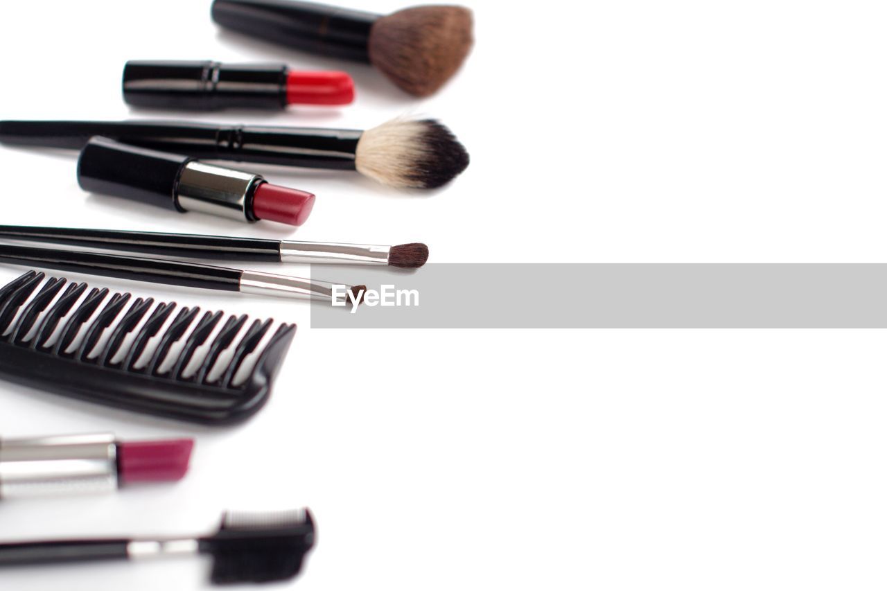 High angle view of make-up brushes against white background