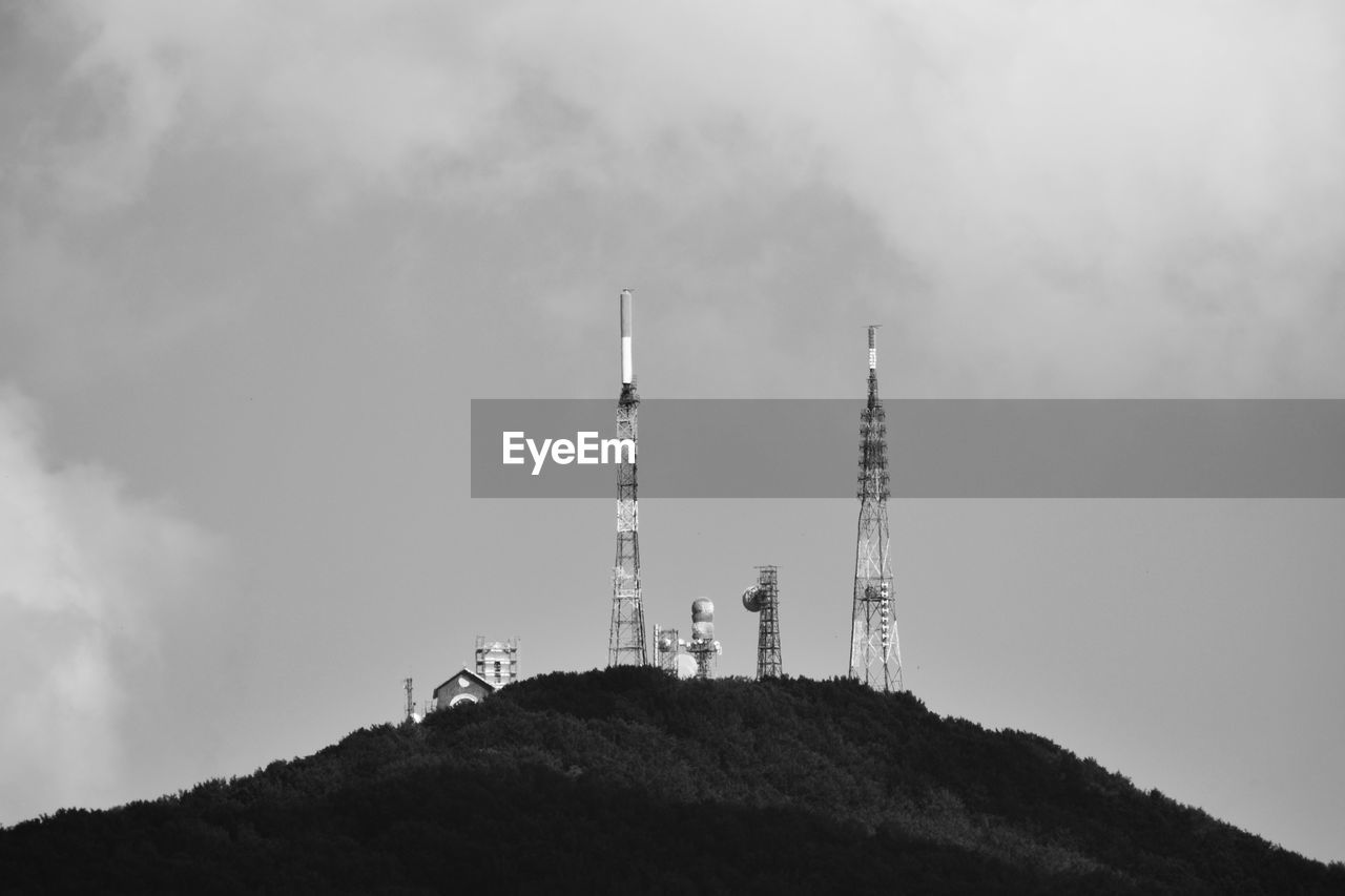 communications tower, broadcasting, communication, sky, technology, tower, global communications, built structure, black and white, architecture, telecommunications equipment, antenna, satellite dish, cloud, satellite, wireless technology, television industry, mountain, nature, monochrome photography, no people, monochrome, radio, low angle view, building exterior, outdoors, environment, telecommunications engineering, industry, land, day