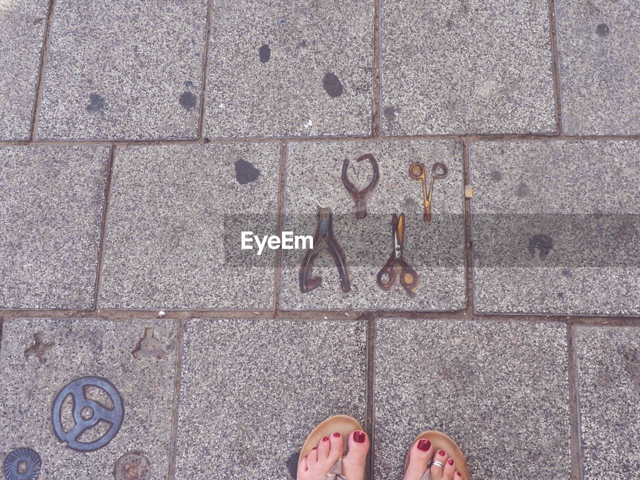 LOW SECTION OF PERSON STANDING ON TILED FLOOR