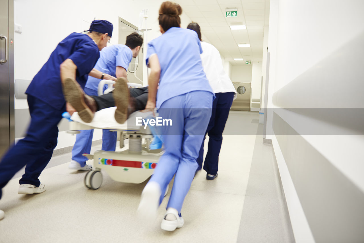 Doctors rushing patient to emergency room in hospital